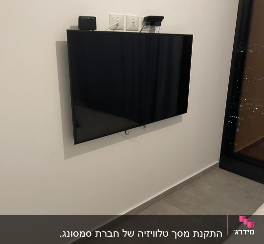 טלוויזיה תלויה על הקיר עם כבלים מחוברים